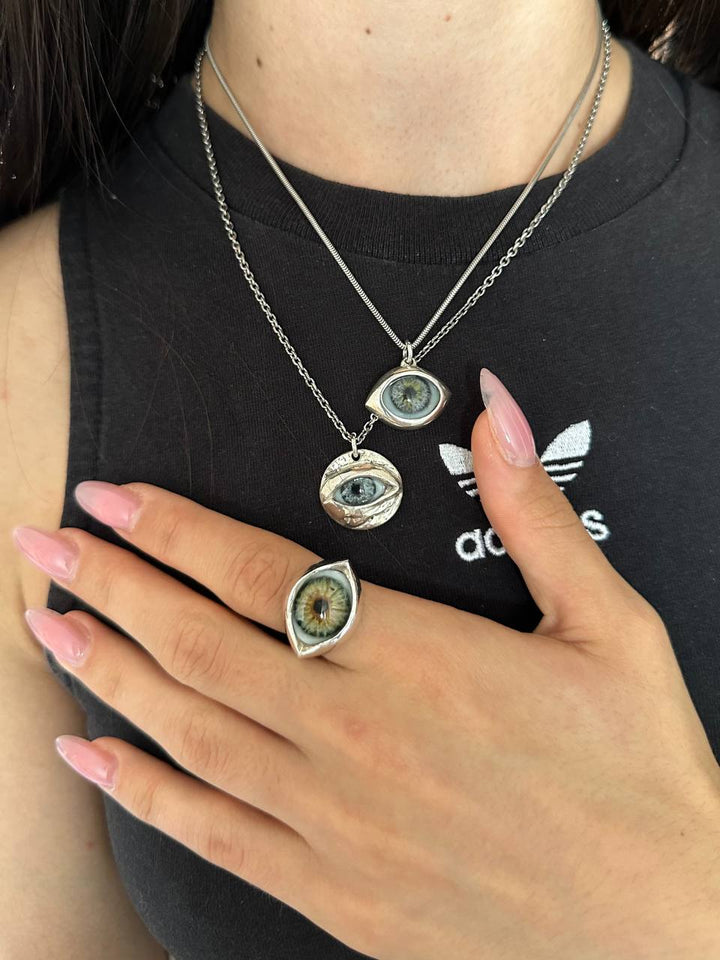 Un anneau en amande porté sous deux pendentifs en forme d’œil