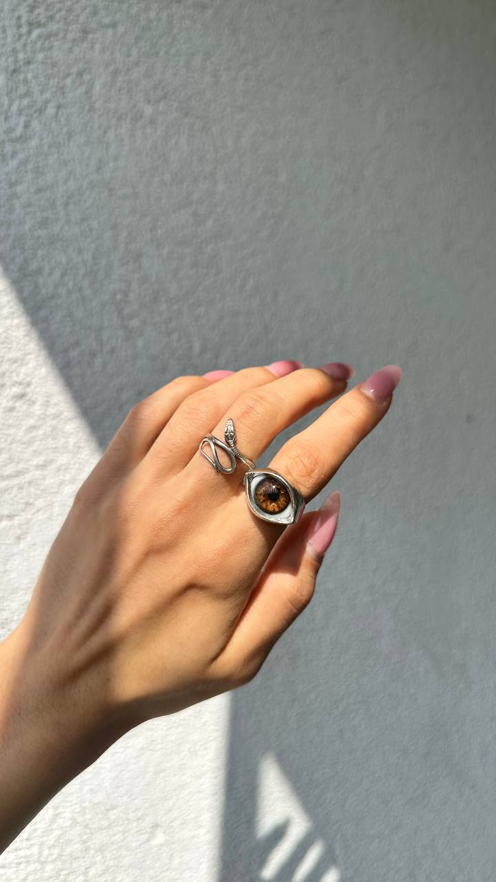 Silver almond eye ring with an amber hand-painted iris, worn in sunlight